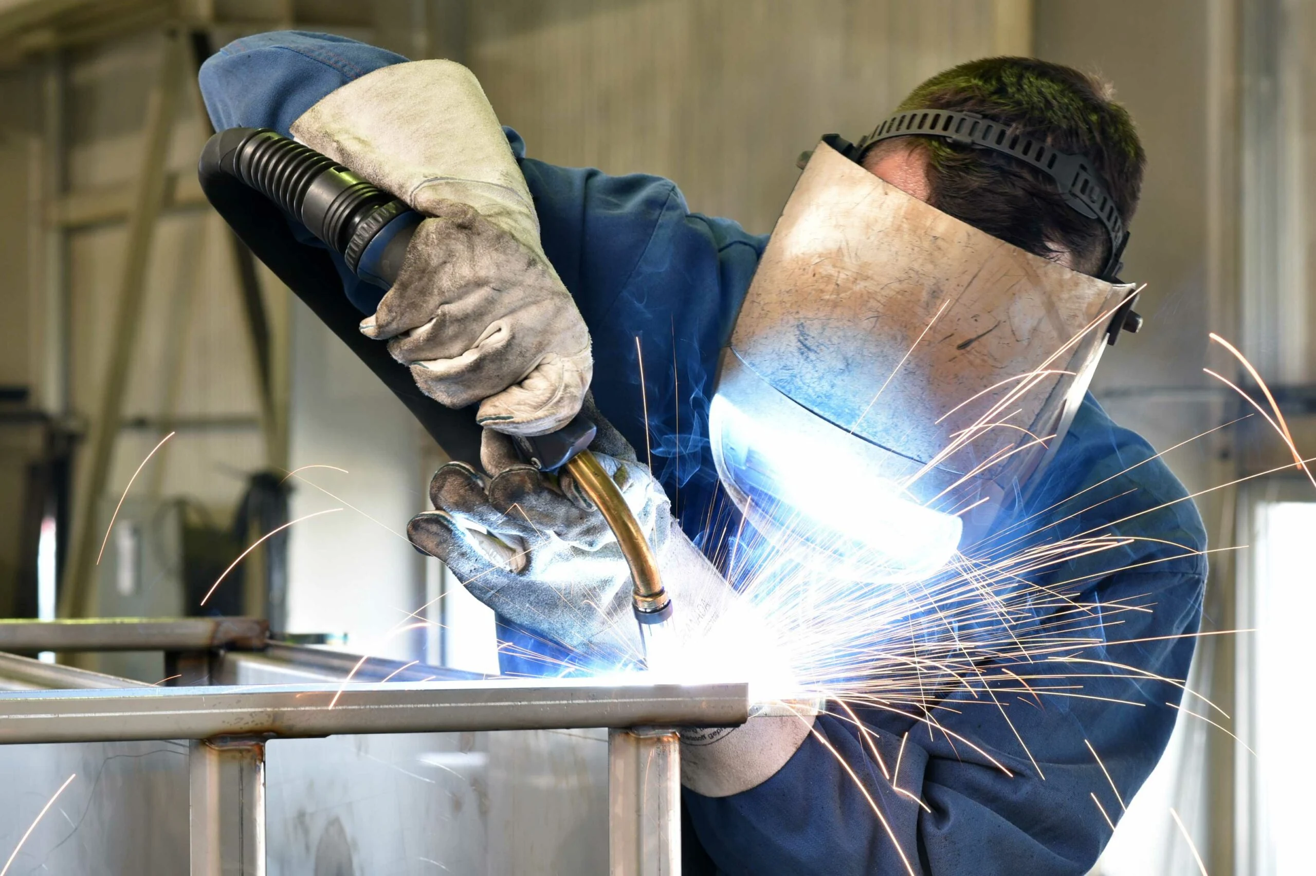 Welder working at the join of a metal frame